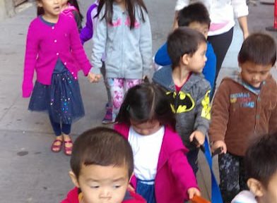 Children holding a walking rope on a neighborhood walk