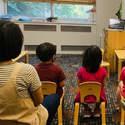 A teacher sitting with children during circle time